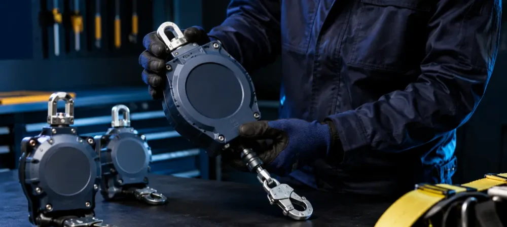 Technician inspecting fall arrest blocks at a safety equipment workshop