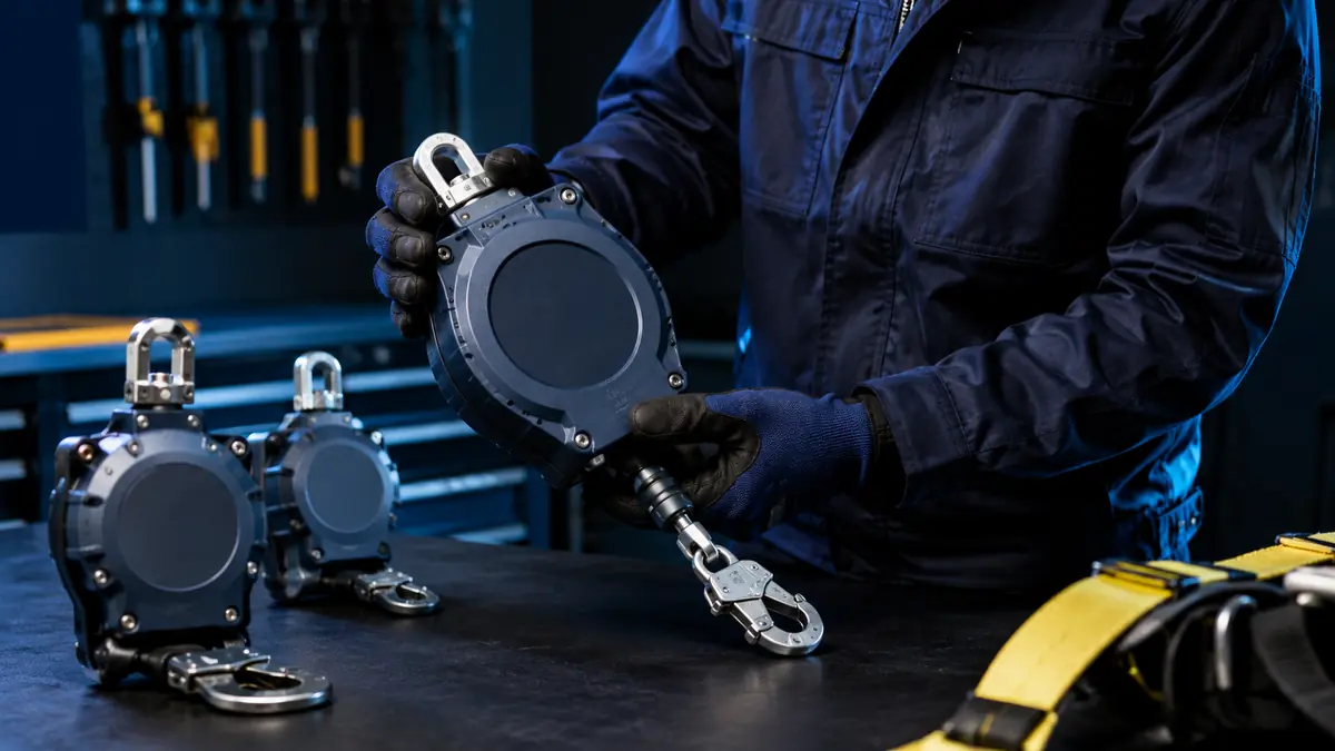 Technician inspecting fall arrest blocks at a safety equipment workshop